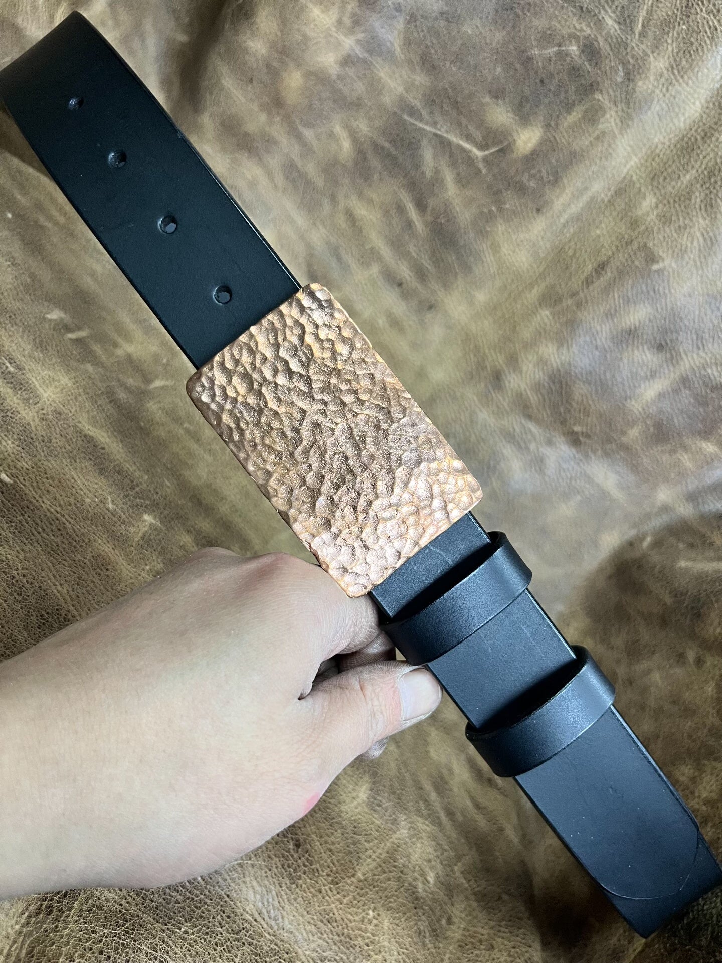 The copper hammered smooth gusset buckle is paired with a custom-ma…