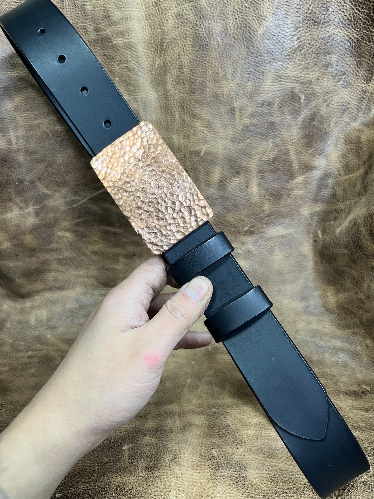 The copper hammered smooth gusset buckle is paired with a custom-ma…
