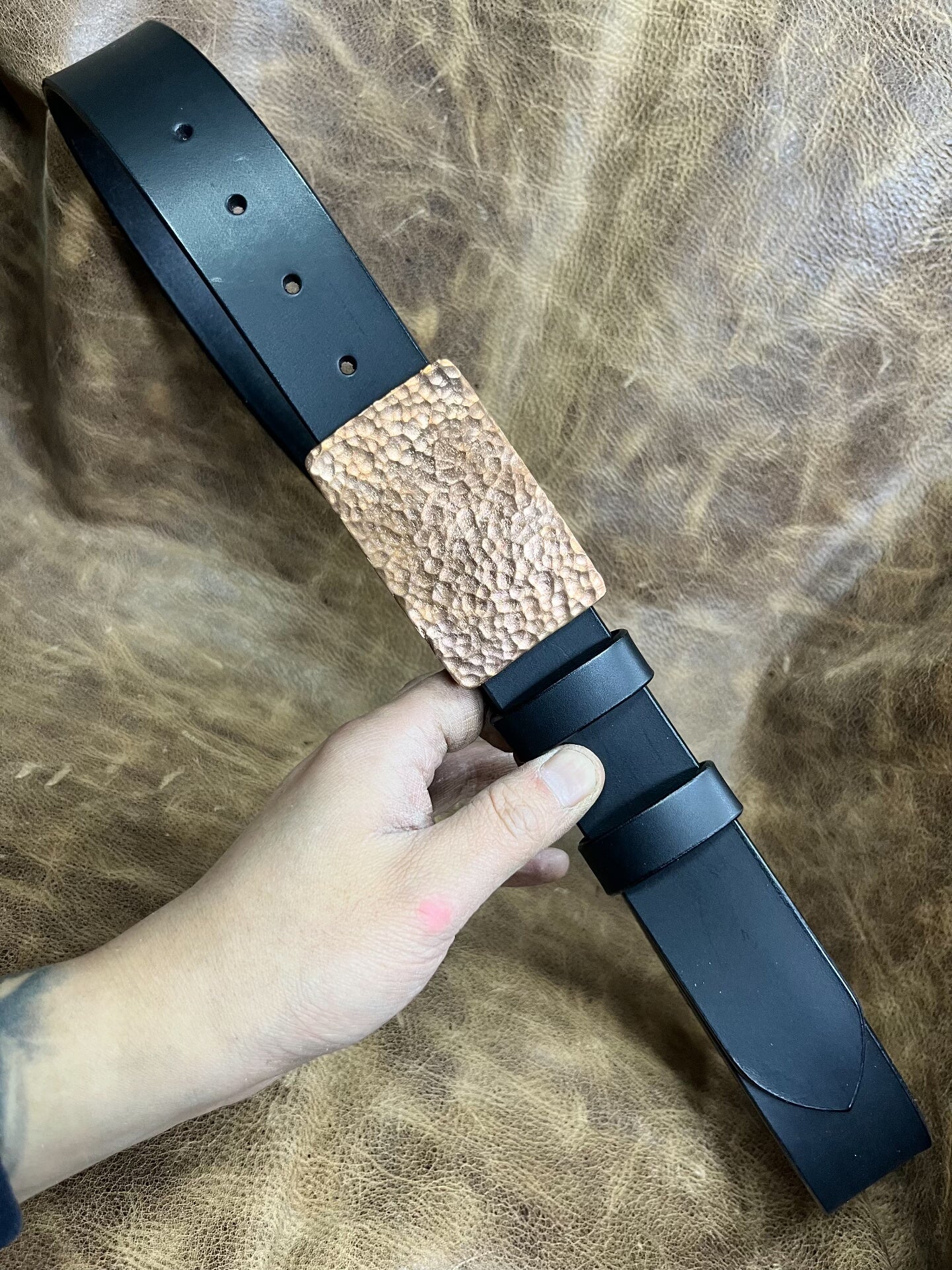 The copper hammered smooth gusset buckle is paired with a custom-ma…