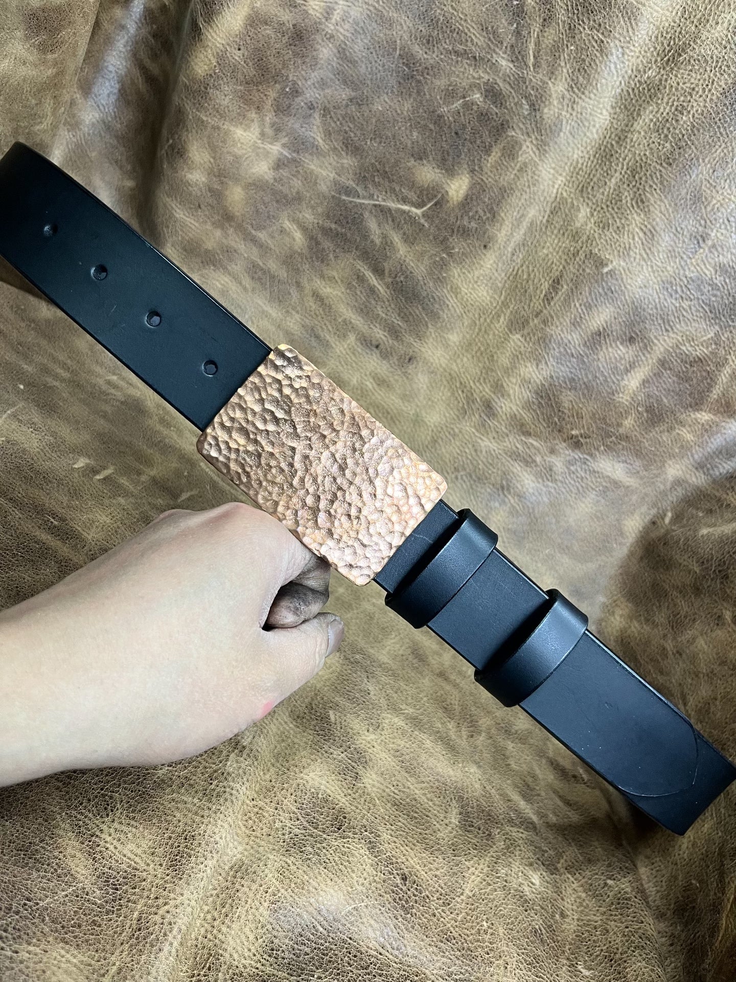 The copper hammered smooth gusset buckle is paired with a custom-ma…